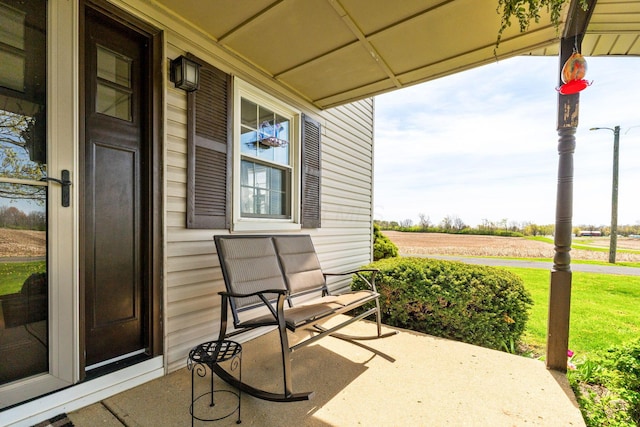 view of patio with a porch and a rural view