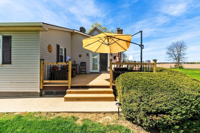 rear view of house with a chimney and a wooden deck