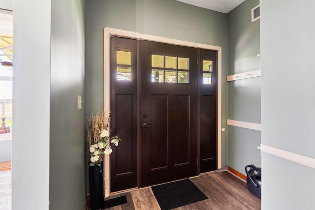 entrance foyer featuring baseboards, visible vents, and dark wood-style floors