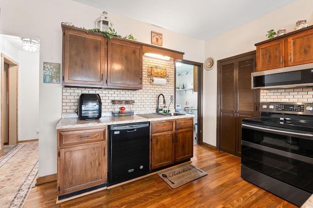 kitchen featuring dark wood finished floors, stainless steel microwave, black dishwasher, and range with two ovens