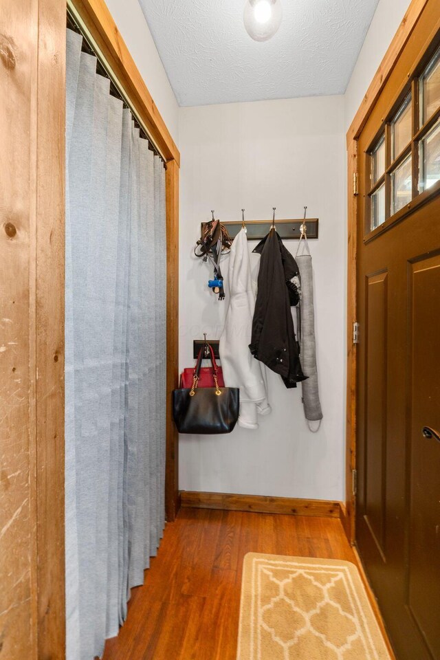 mudroom with baseboards, wood finished floors, and a textured ceiling