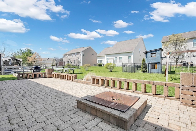 view of patio featuring fence, a residential view, and a trampoline