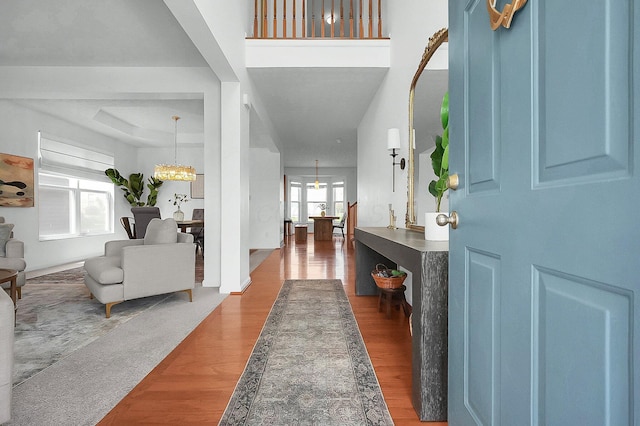 foyer entrance with wood finished floors and a chandelier