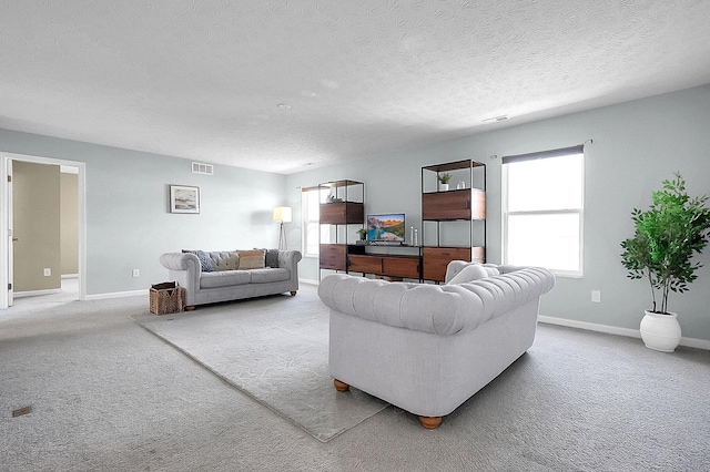 carpeted living room with baseboards, visible vents, and a textured ceiling