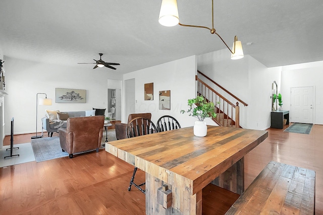 dining room with wood finished floors, stairs, and ceiling fan