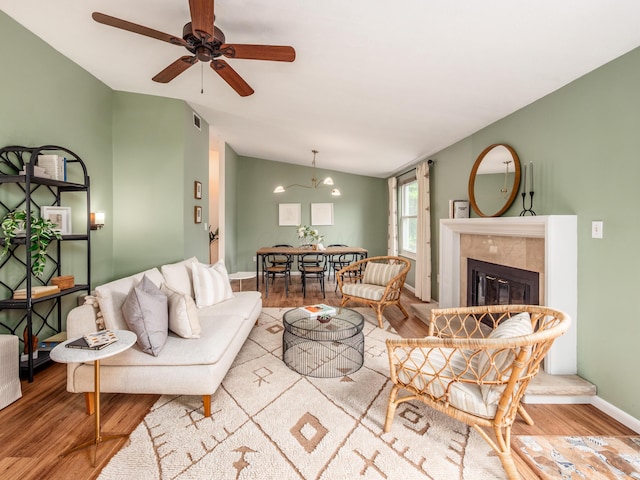 3794 Bridle Ct, Columbus, OH 43221 - living room with wood finished floors, vaulted ceiling, baseboards, ceiling fan, and a tiled fireplace