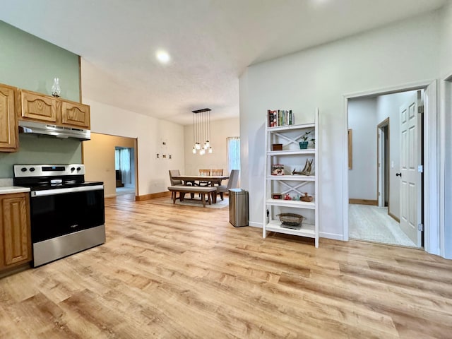 kitchen with stainless steel range with electric cooktop, light wood-type flooring, baseboards, light countertops, and under cabinet range hood