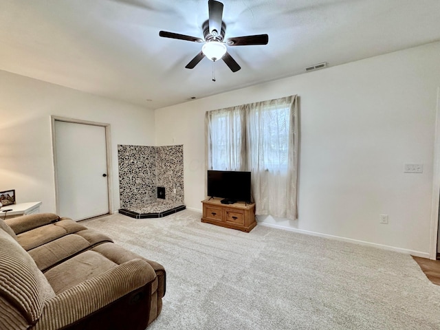 living room featuring ceiling fan, carpet floors, visible vents, and baseboards
