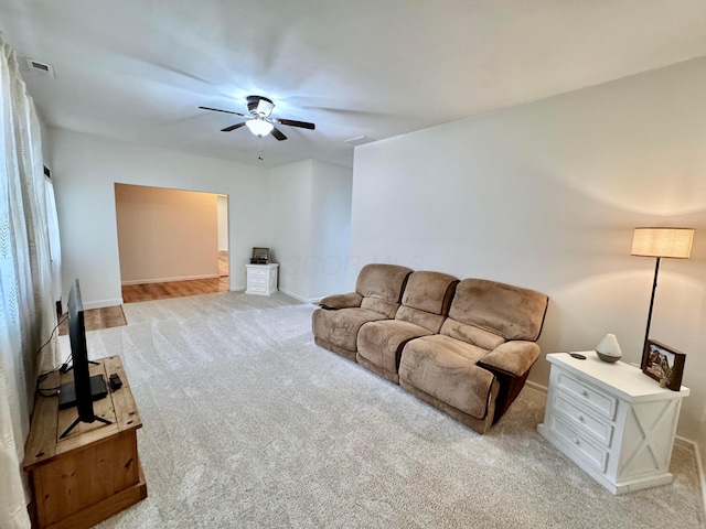 living area with carpet floors, visible vents, baseboards, and ceiling fan