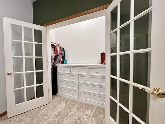 walk in closet featuring french doors and carpet flooring