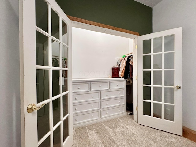 walk in closet with french doors and carpet flooring