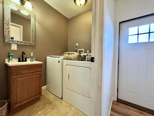 laundry room with a sink, washer and clothes dryer, and cabinet space