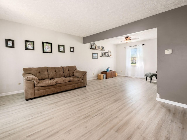 5407 Davidson Rd, Hilliard, OH 43026 - living room featuring light wood-style floors, baseboards, a ceiling fan, and a textured ceiling