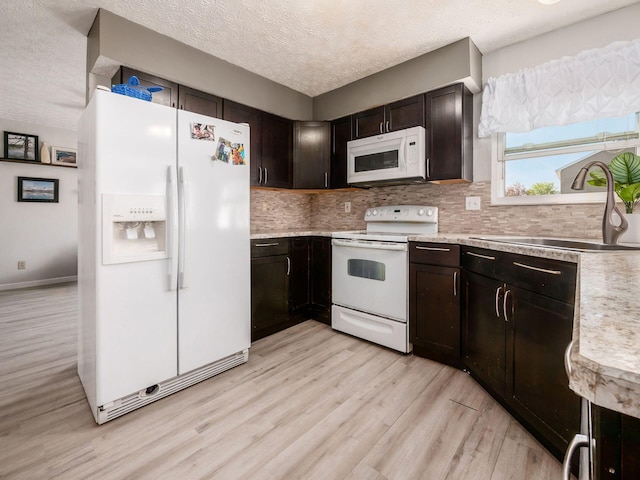 5407 Davidson Rd, Hilliard, OH 43026 - kitchen featuring a textured ceiling, a sink, light countertops, light wood finished floors, and white appliances