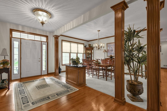 12372 Brook Forest Cir NW, Pickerington, OH 43147 - entryway with decorative columns, a notable chandelier, and light wood-style floors