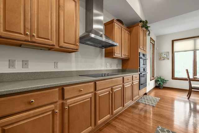 12372 Brook Forest Cir NW, Pickerington, OH 43147 - kitchen with wall chimney exhaust hood, black electric cooktop, brown cabinets, double oven, and light wood finished floors