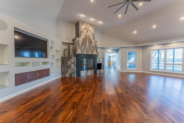 unfurnished living room featuring built in features, ceiling fan, baseboards, and wood finished floors