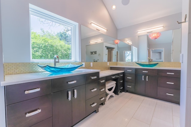 full bathroom with plenty of natural light, decorative backsplash, lofted ceiling, and vanity