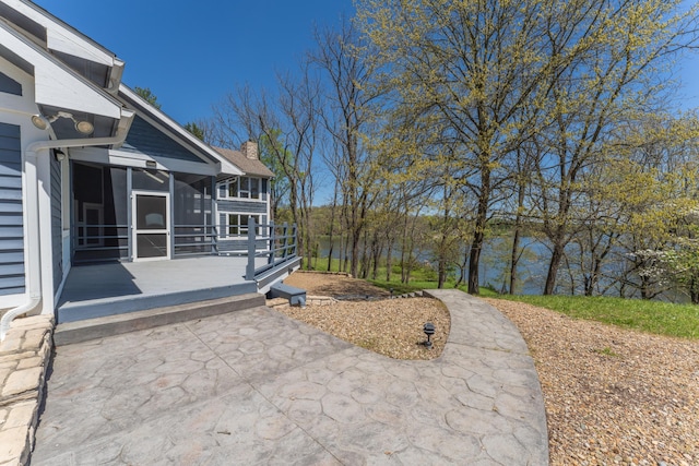 view of patio featuring a deck and a sunroom