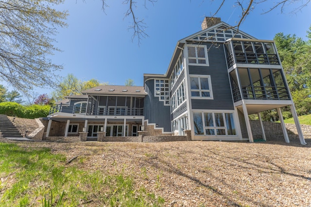 rear view of house with a chimney and a sunroom