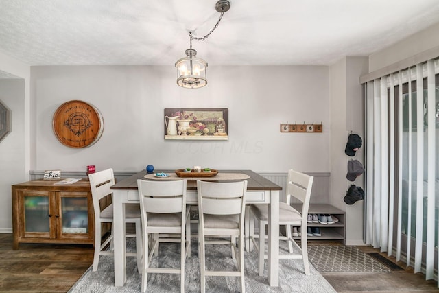 dining room featuring wood finished floors and an inviting chandelier