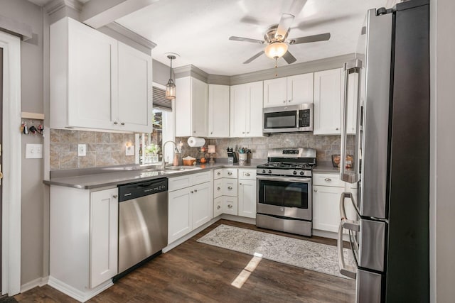 kitchen featuring a ceiling fan, tasteful backsplash, a sink, stainless steel appliances, and white cabinetry