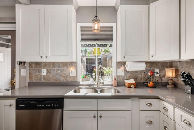 kitchen with stainless steel dishwasher, tasteful backsplash, a sink, hanging light fixtures, and white cabinetry