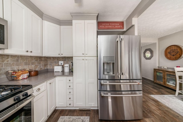 kitchen with white cabinets, stainless steel appliances, a textured ceiling, and dark wood-style flooring