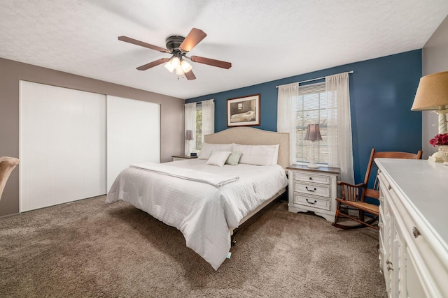 carpeted bedroom with a textured ceiling, a closet, ceiling fan, and multiple windows