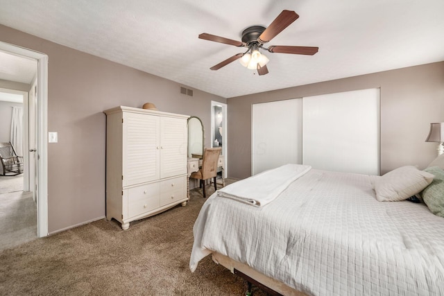 carpeted bedroom with visible vents and a ceiling fan