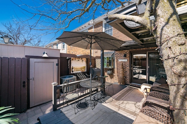 wooden deck featuring an outdoor structure, central AC, and a shed
