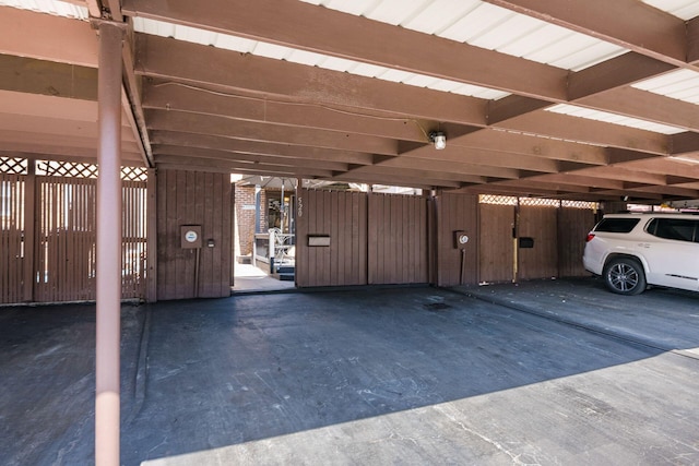 covered parking lot featuring fence