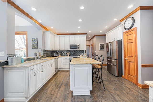6707 Meadow Glen Dr S, Westerville, OH 43082 - kitchen with a kitchen breakfast bar, a sink, backsplash, light stone counters, and appliances with stainless steel finishes