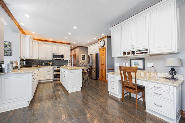 6707 Meadow Glen Dr S, Westerville, OH 43082 - kitchen with white cabinets, dark wood finished floors, a breakfast bar area, and stainless steel appliances