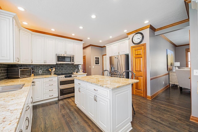 6707 Meadow Glen Dr S, Westerville, OH 43082 - kitchen featuring crown molding, appliances with stainless steel finishes, baseboards, dark wood-style flooring, and a kitchen island