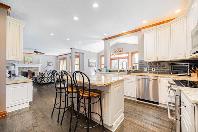 6707 Meadow Glen Dr S, Westerville, OH 43082 - kitchen featuring open floor plan, a breakfast bar area, ceiling fan, stainless steel appliances, and dark wood-type flooring