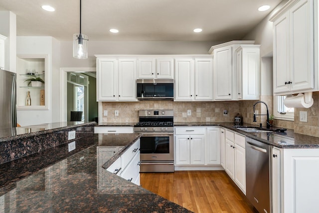 478 Riverbend Ave, Powell, OH 43065 - kitchen featuring stainless steel appliances, a sink, light wood-style floors, hanging light fixtures, and white cabinetry