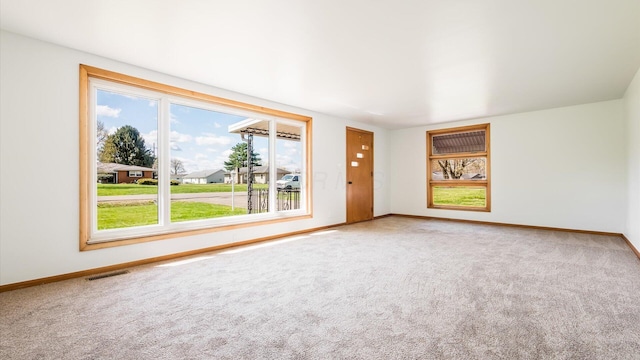 carpeted empty room with baseboards and visible vents