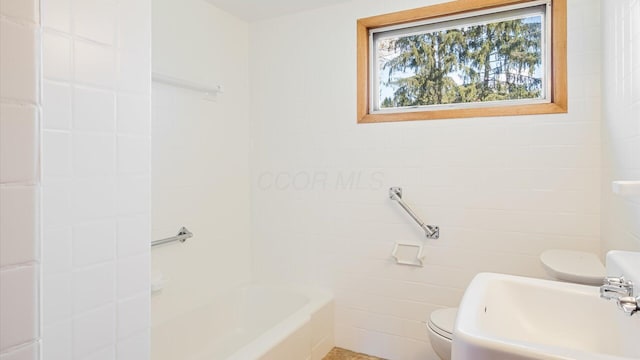 full bath with tile walls, a sink, and toilet