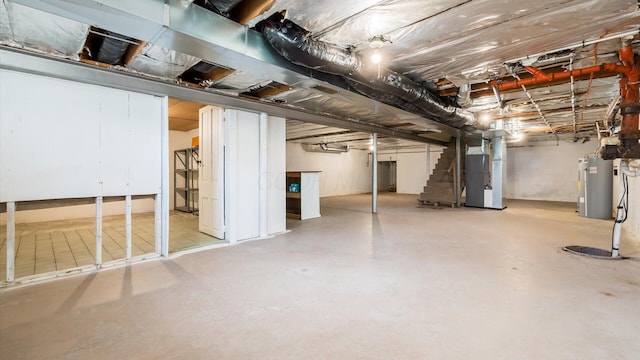 unfinished below grade area with water heater, stairway, and heating unit