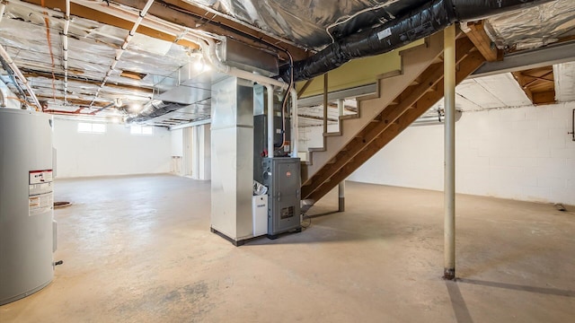 below grade area featuring heating unit, electric water heater, and stairs
