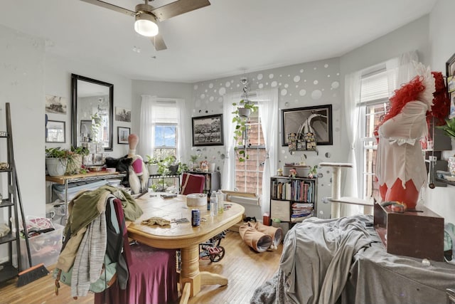 dining area featuring wallpapered walls, wood finished floors, and a ceiling fan