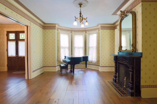 115 E Wheeling St, Lancaster, OH 43130 - living area with wallpapered walls, a chandelier, plenty of natural light, dark wood-style flooring, and crown molding
