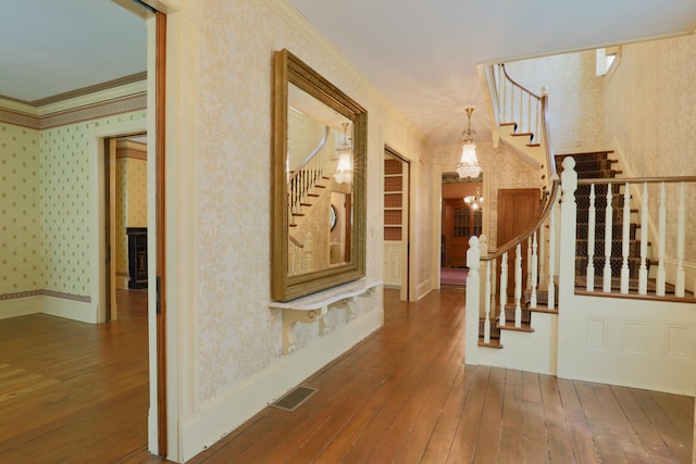 115 E Wheeling St, Lancaster, OH 43130 - foyer entrance featuring wallpapered walls, stairs, hardwood / wood-style flooring, ornamental molding, and a chandelier