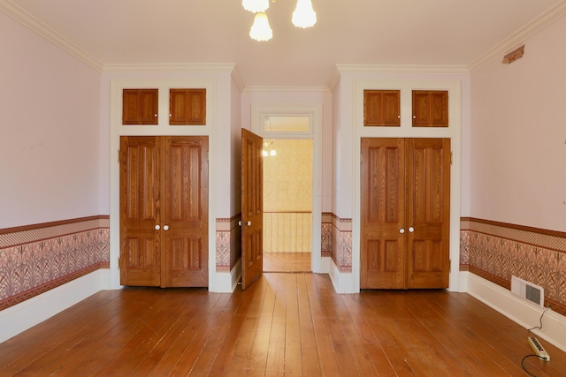 115 E Wheeling St, Lancaster, OH 43130 - spare room with wood-type flooring, wainscoting, ornamental molding, and a chandelier