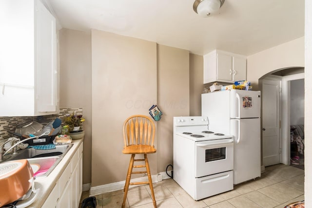 1282-1284 Linwood Ave, Columbus, OH 43206 - kitchen with a sink, white appliances, white cabinetry, arched walkways, and backsplash