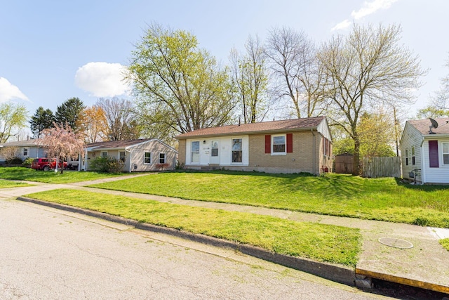 ranch-style house with fence, a front lawn, and brick siding