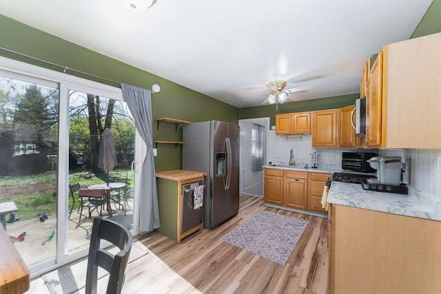 kitchen featuring light countertops, backsplash, light wood-style floors, and stainless steel appliances