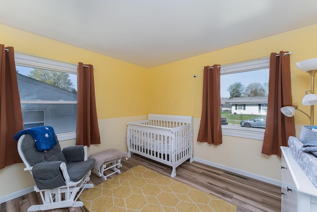 bedroom featuring wood finished floors, multiple windows, and visible vents