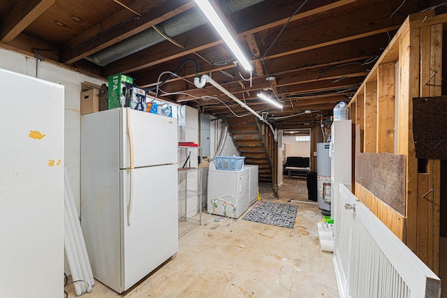 unfinished below grade area featuring water heater, stairway, freestanding refrigerator, independent washer and dryer, and electric panel